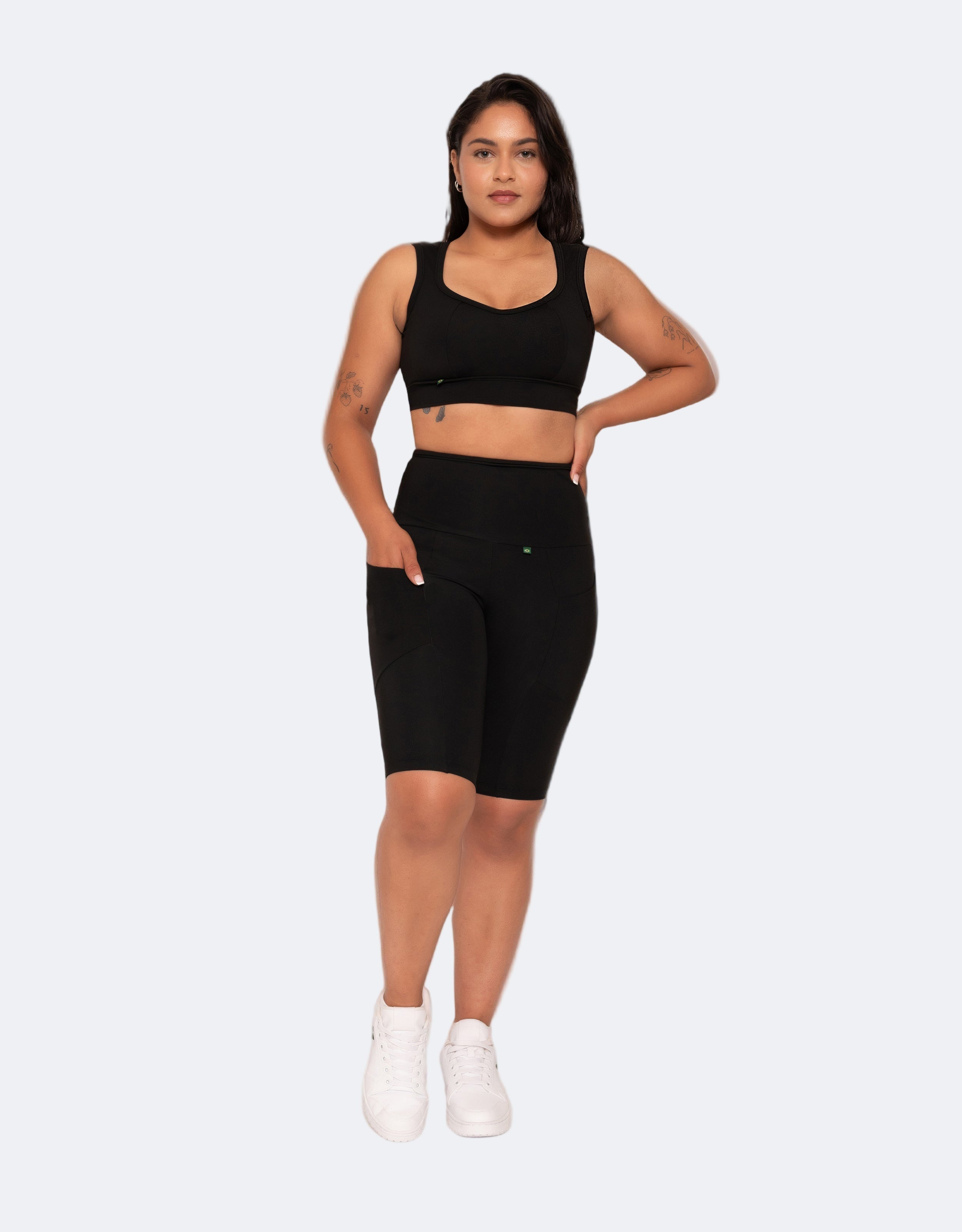 Model wears high performance compression knee length shorts featuring deep pockets on both sides and a matching  black active crop top with full support.  Premium fabrics, ethically made in Brazil 