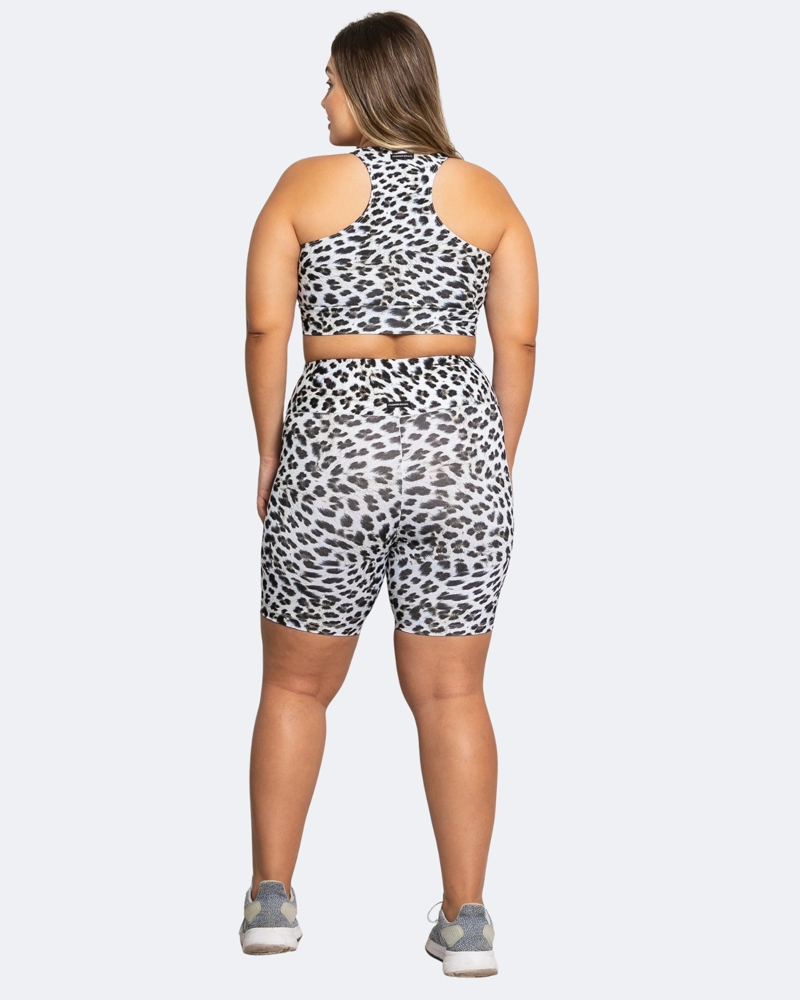 Person wearing a leopard print athletic outfit on a white background