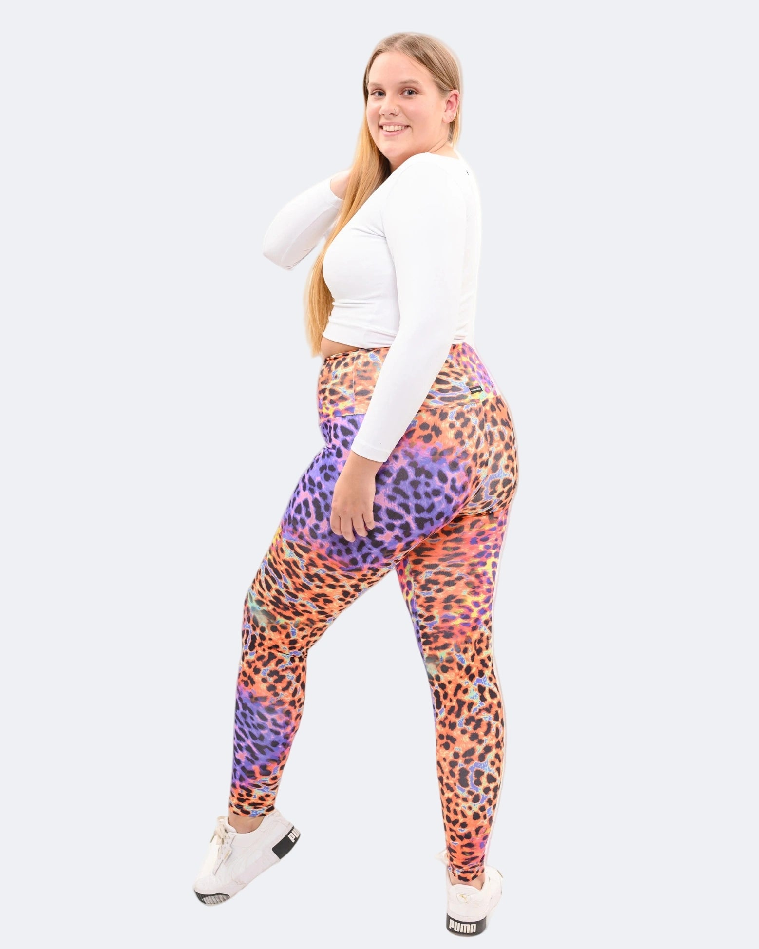 Woman wearing colorful patterned leggings on a white background