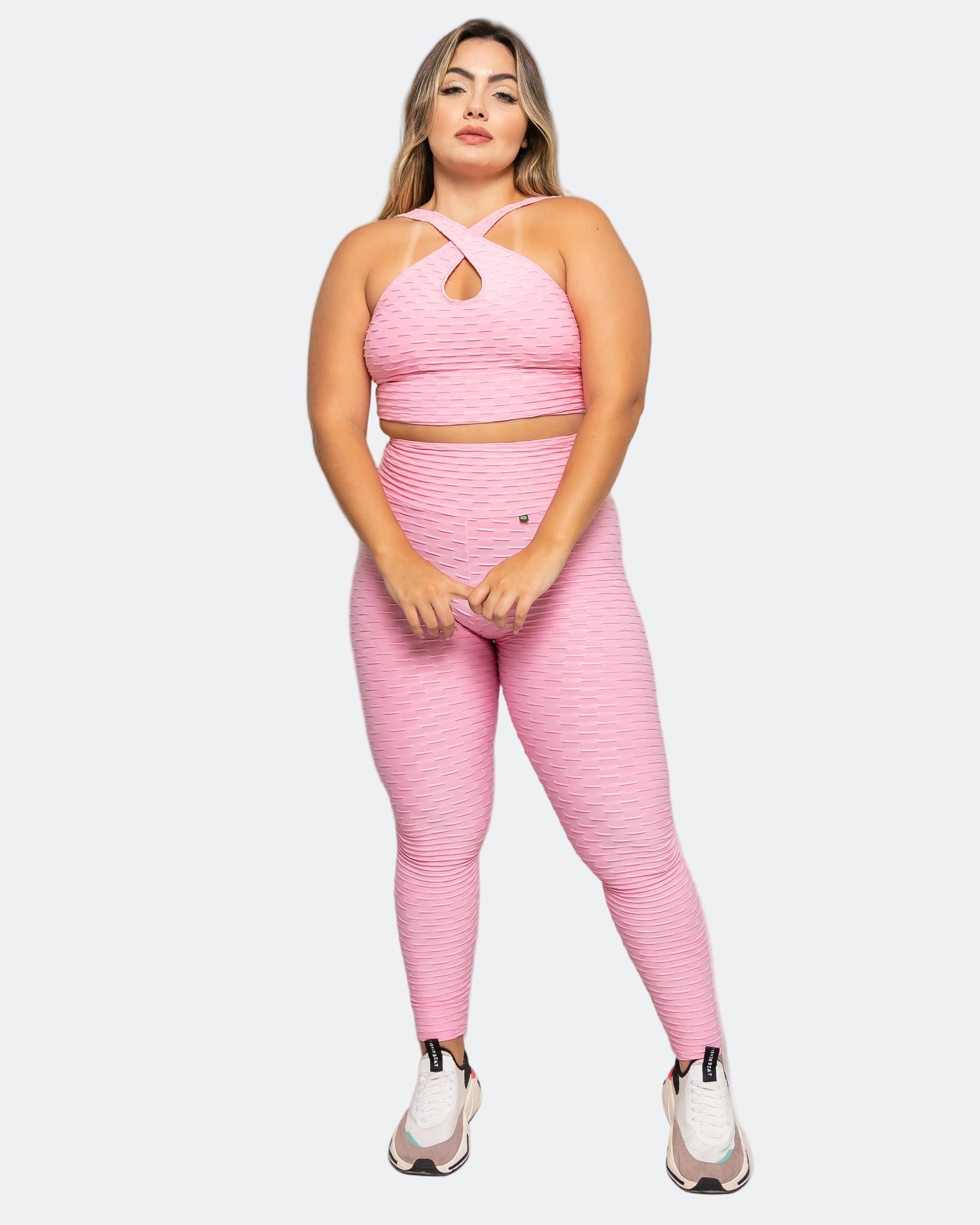Woman wearing a pink athletic outfit on a white background