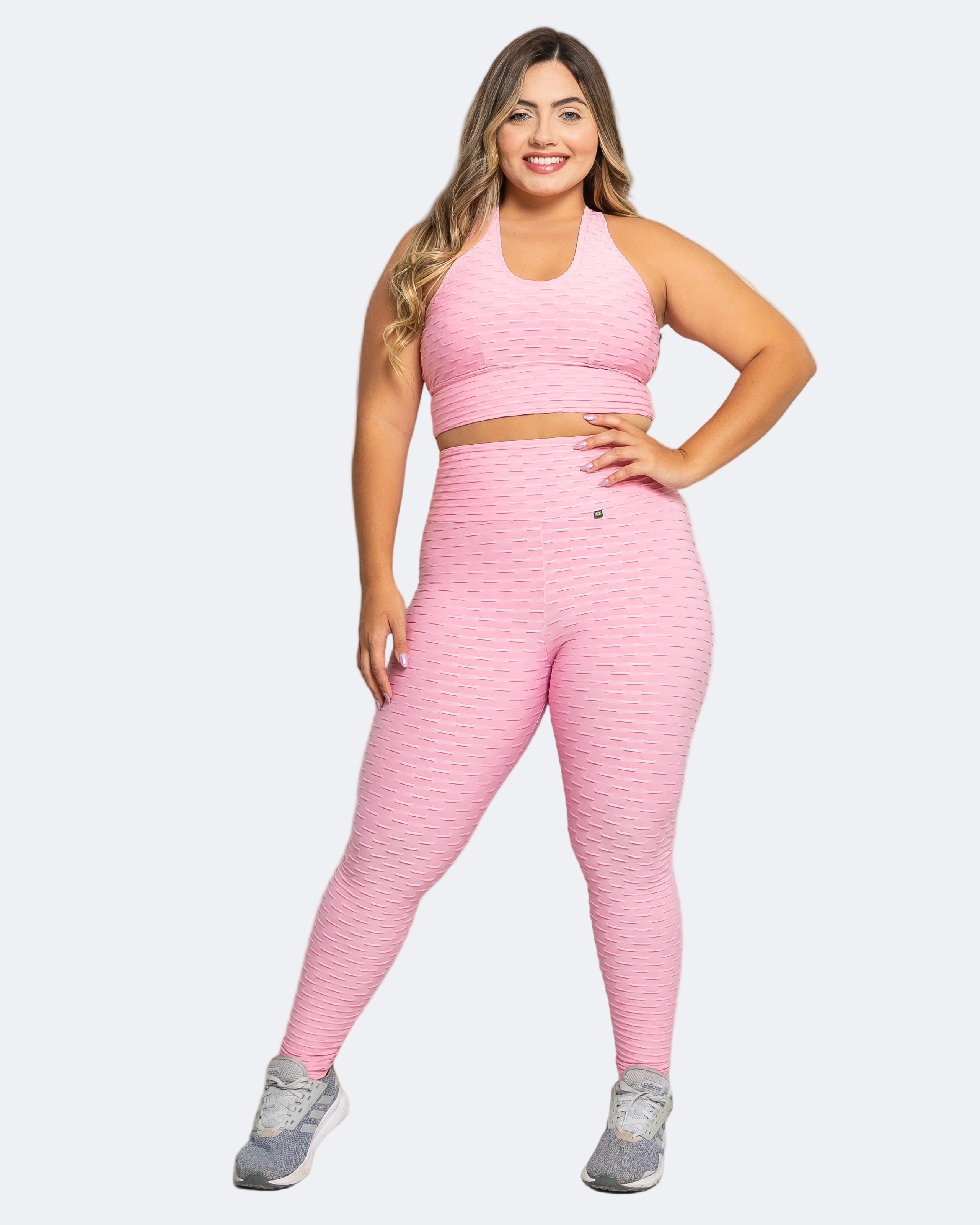 Woman wearing a pink athletic outfit on a white background
