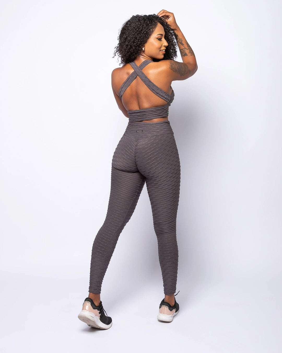 Woman wearing a gray athletic outfit on a white background