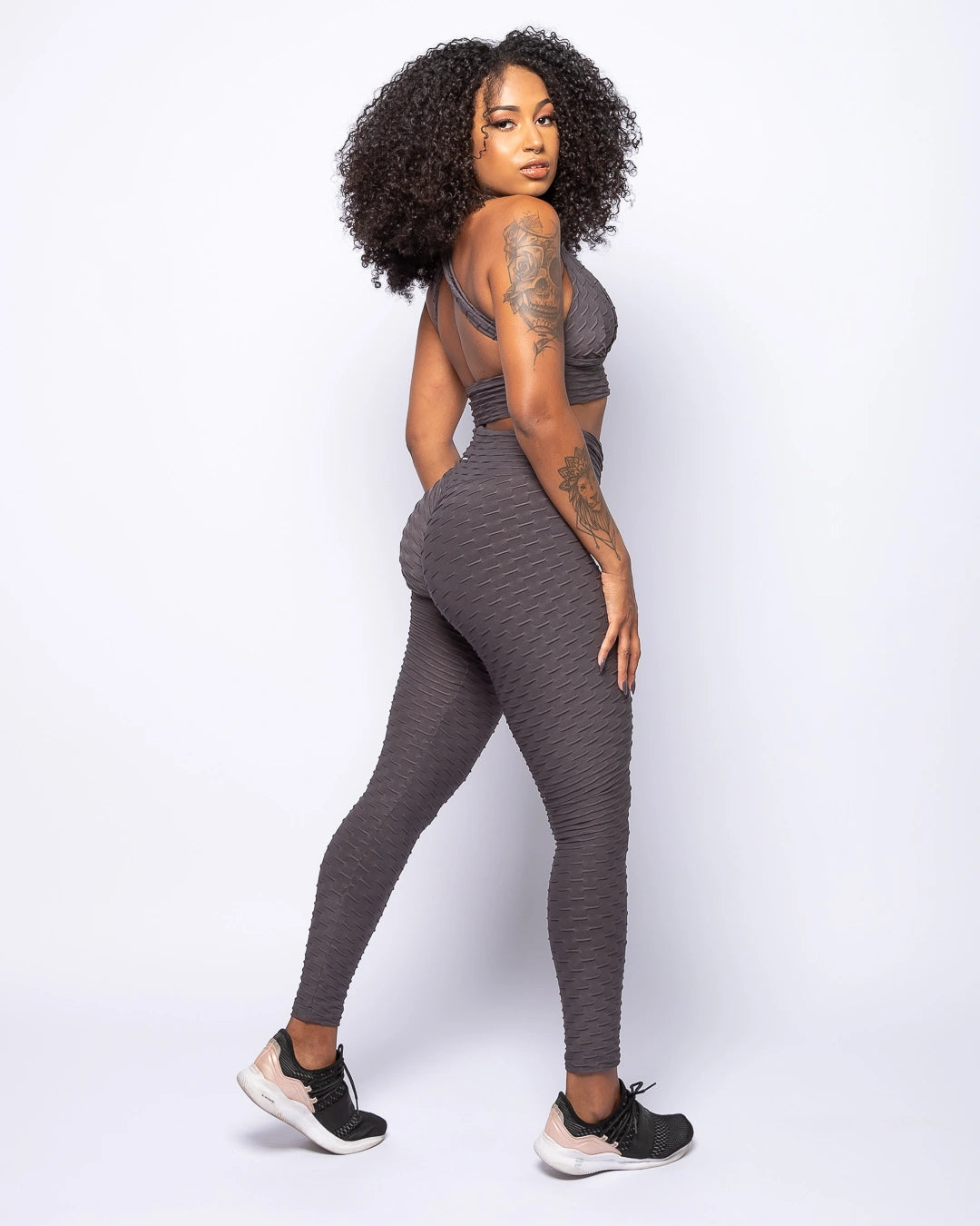 Woman wearing a gray athletic outfit on a white background