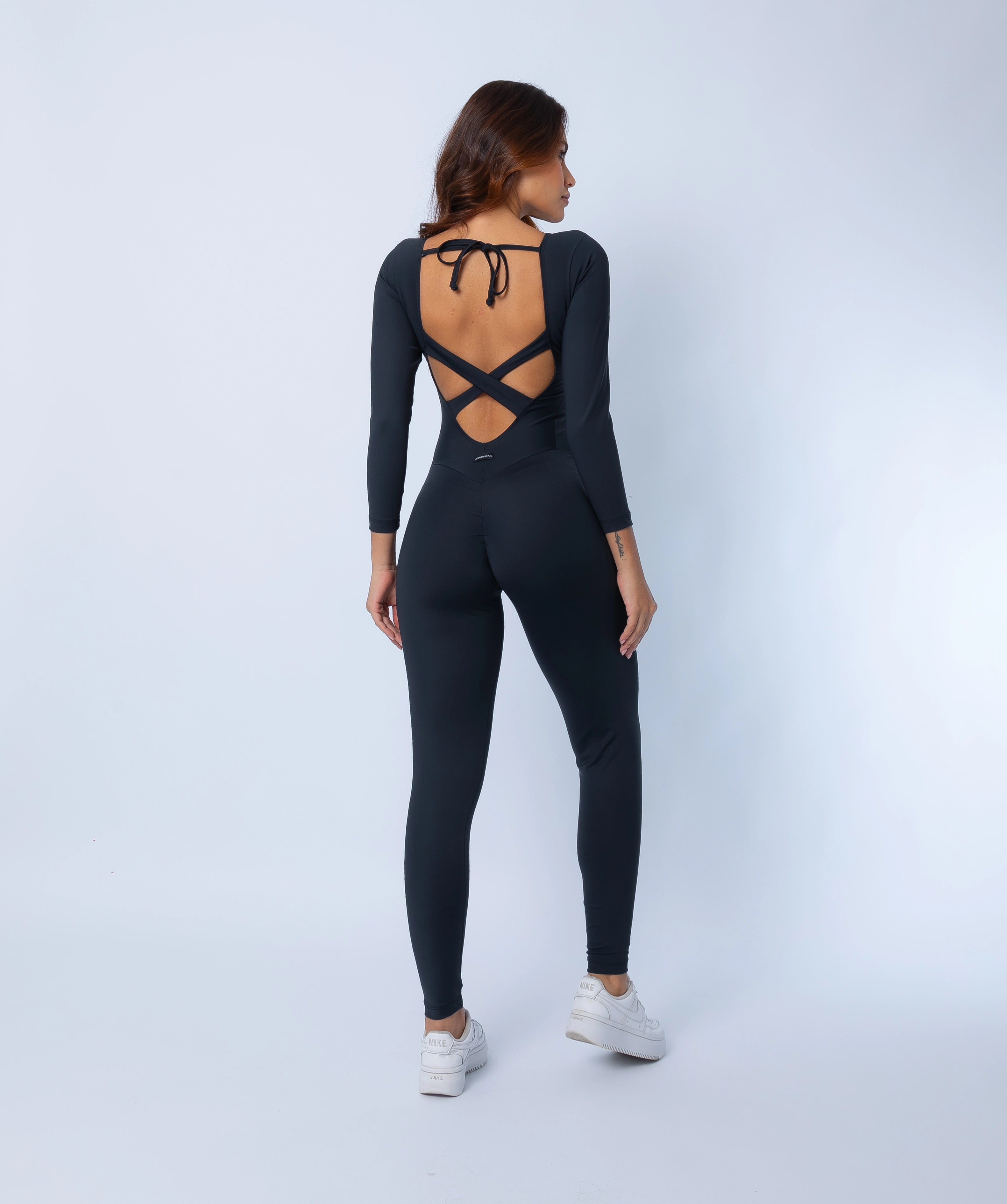 Fashion Brazil Elevate Long Sleeve Jumpsuit back view with criss-cross open back straps, tie closure, and scrunch-back seam detail.