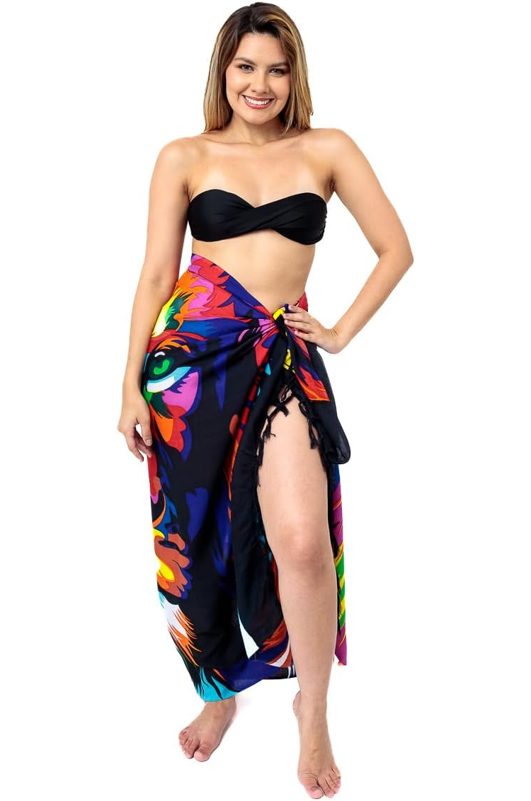 The image shows a sarong featuring a colourful, artistic depiction of a lion's face. Tasseled edge and showcases a vibrant, multicoloured lion design, which adds a unique and eye-catching element.