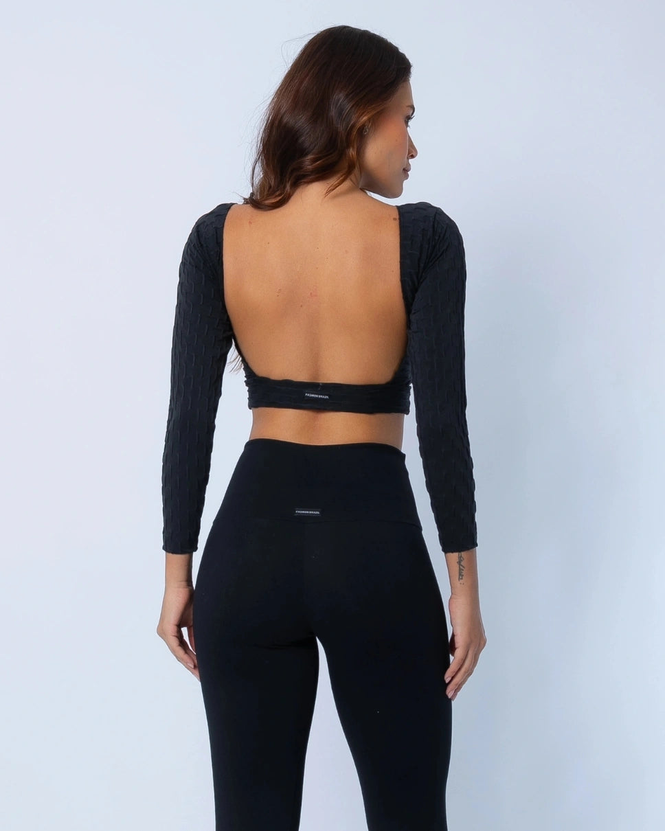 Model is wearing a black long-sleeve crop top and leggings on a light gray background