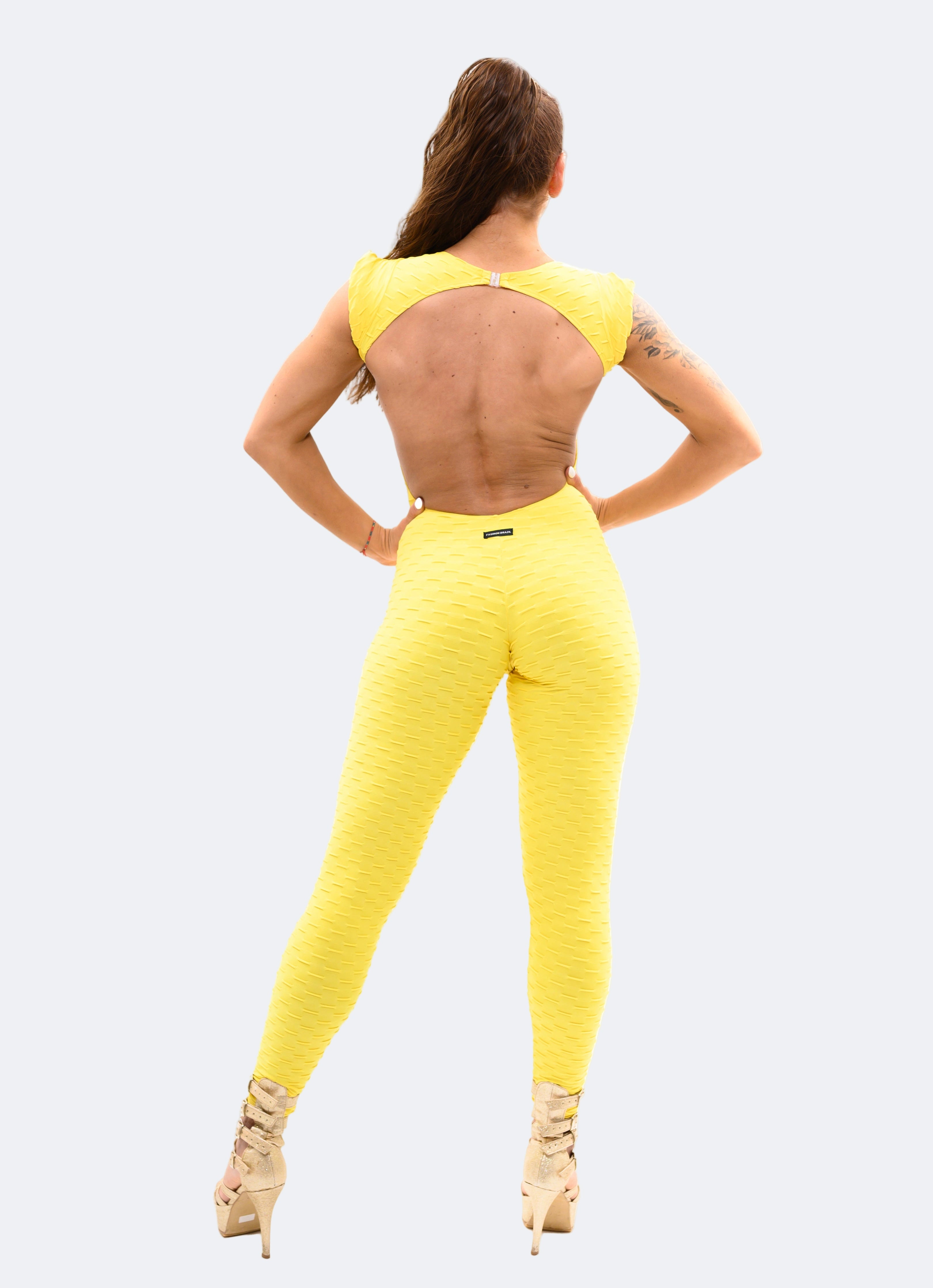 Person wearing a yellow outfit with cut-out design on a light gray background