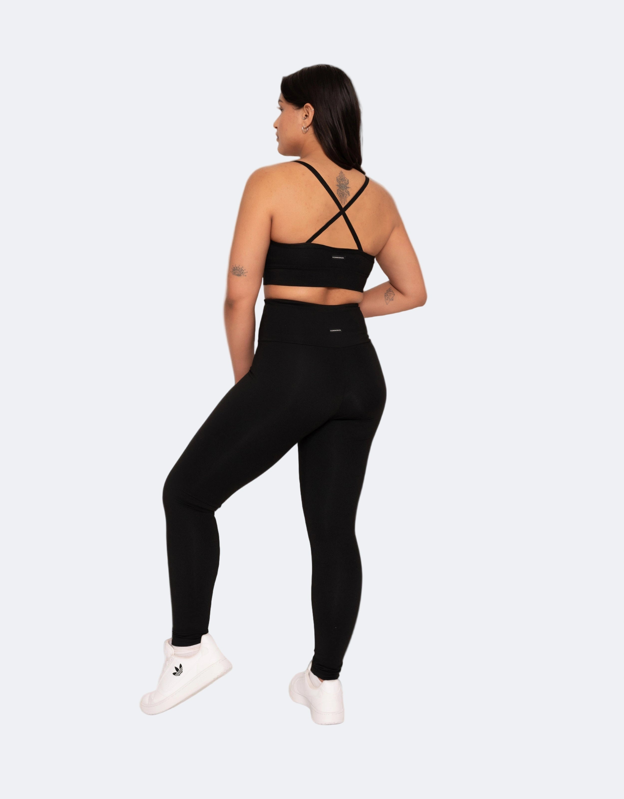 Back details of  high compression black high waisted black leggings  and matching top on a white background