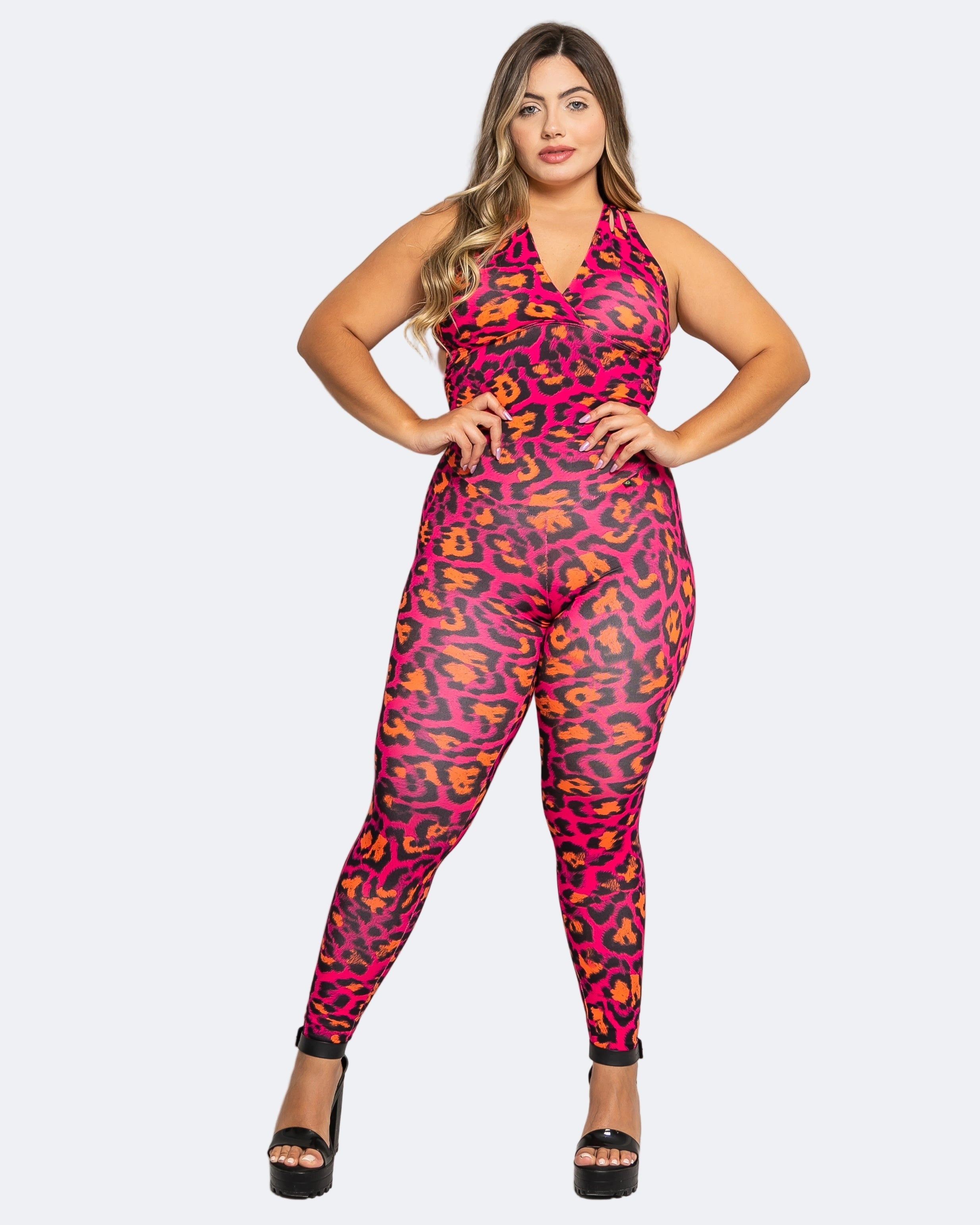 Woman wearing a pink and orange leopard print jumpsuit on a white background