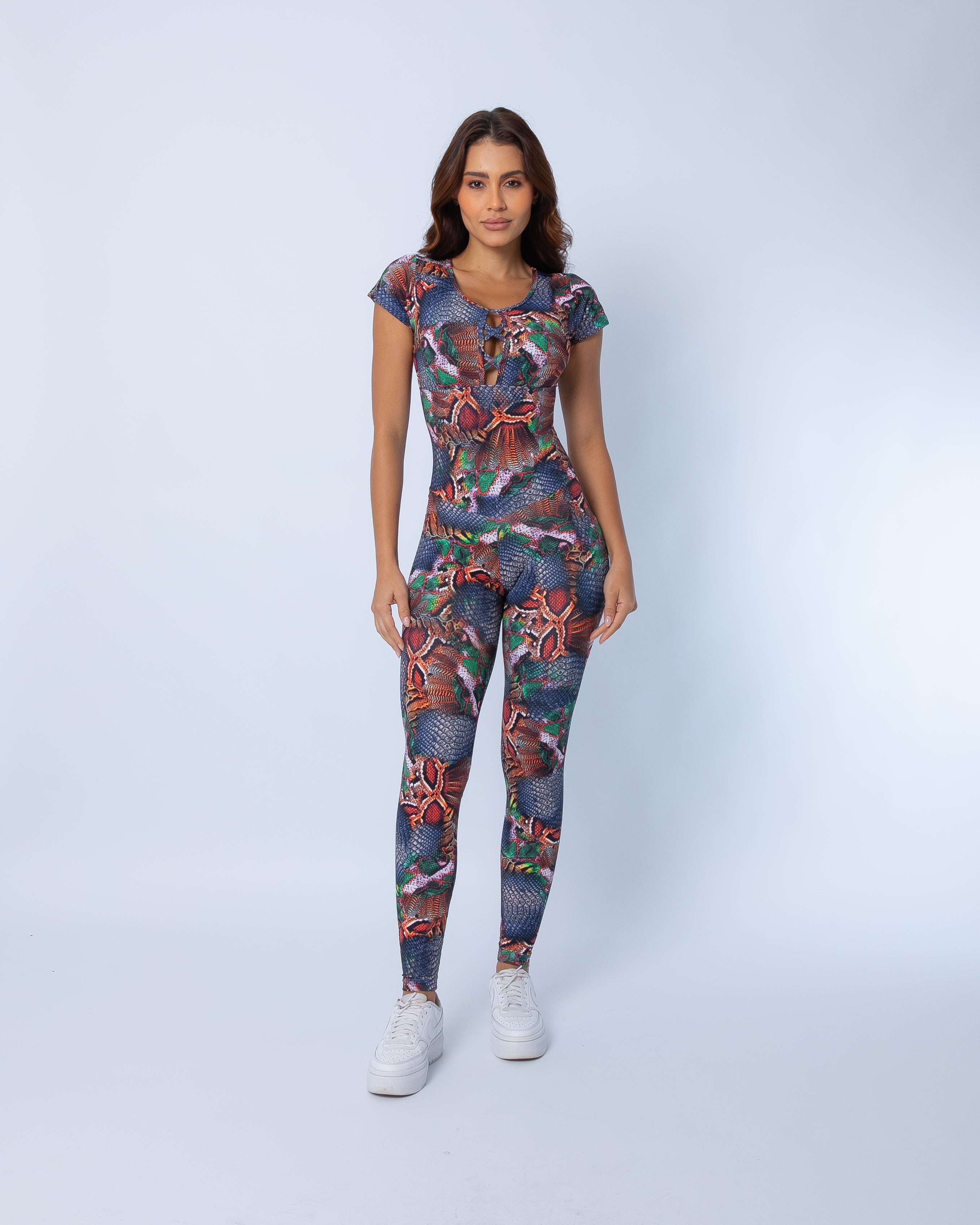 Copper Cobra Cap Sleeve jumpsuit front view, featuring lace-up neckline, cap sleeves, and copper, denim, and green snake-print pattern on a white background.