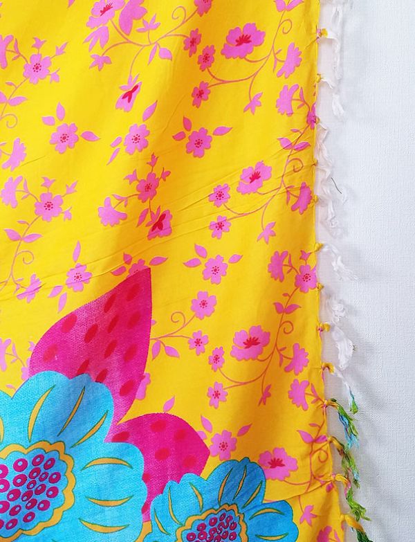Pedra da Gávea sarong close-up showing yellow background with pink flowers and fringe tassels on a white background — Fashion Brazil