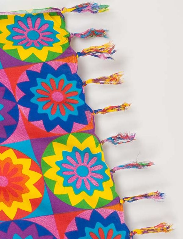 The image shows a sarong featuring a colourful, artistic depiction of a lion's face. Tasseled edge and showcases a vibrant, multicoloured lion design, which adds a unique and eye-catching element.